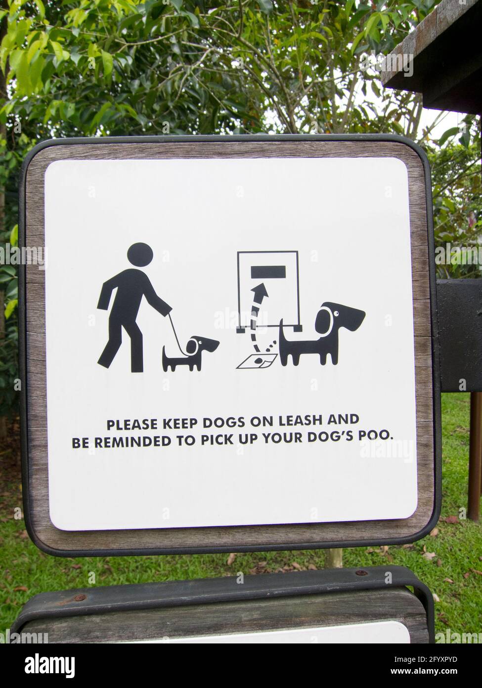 A sign in a park to pick up your dog's poop and dispose of it properly