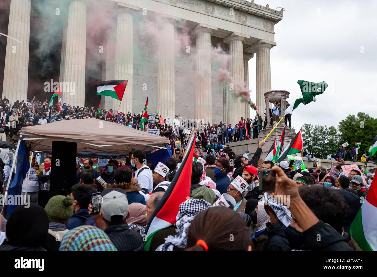 Washington, DC, USA, May 29, 2021.  Pictured: A man releases plumes of red and green smoke during the National March for Palestine at the Lincoln Memorial.  Thousands of people from the eastern half of the United States came to Washington to participate in the march.  American Muslims for Palestine and the US Council of Muslim Organizations co-hosted the event with 7 partnering organizations, and an additional 109 organizations endoresed the march.  Credit: Allison Bailey / Alamy Live News Stock Photo