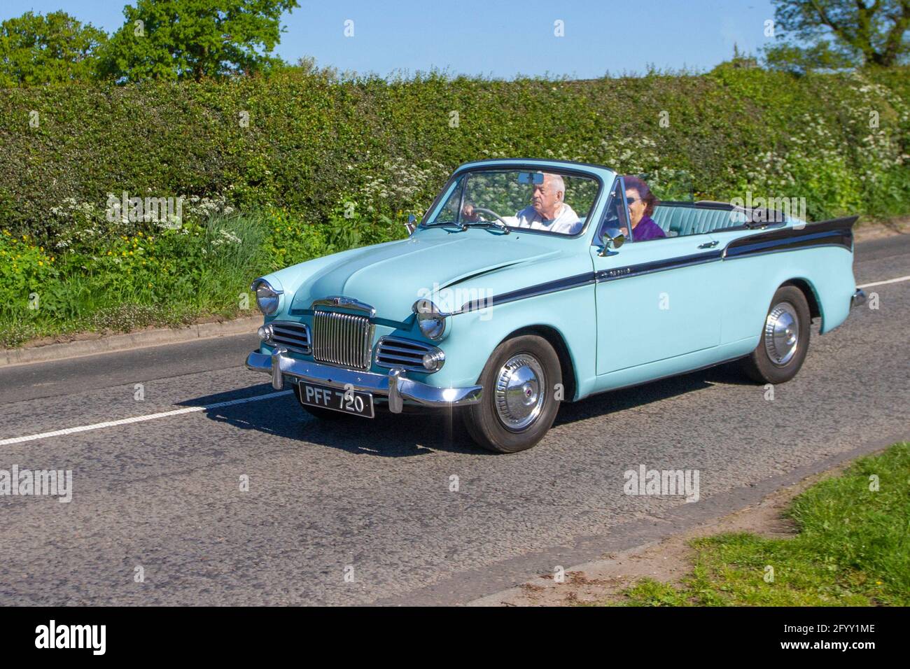 1958 50s fifties blue two-tone Sunbeam Rapier 1494cc four-seater, two-door cabriolet; Vehicular traffic, moving vehicles, cars, vehicle driving  en-route to Capesthorne Hall classic May car show, Cheshire, UK Stock Photo
