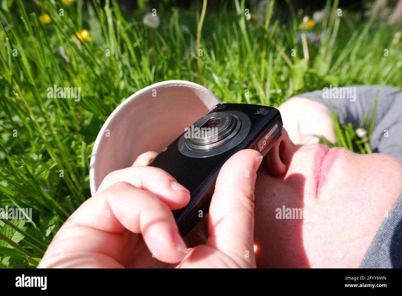 Girl lying on the grass shoots. St. Veronica's Day Photographer's Day . Stock Photo