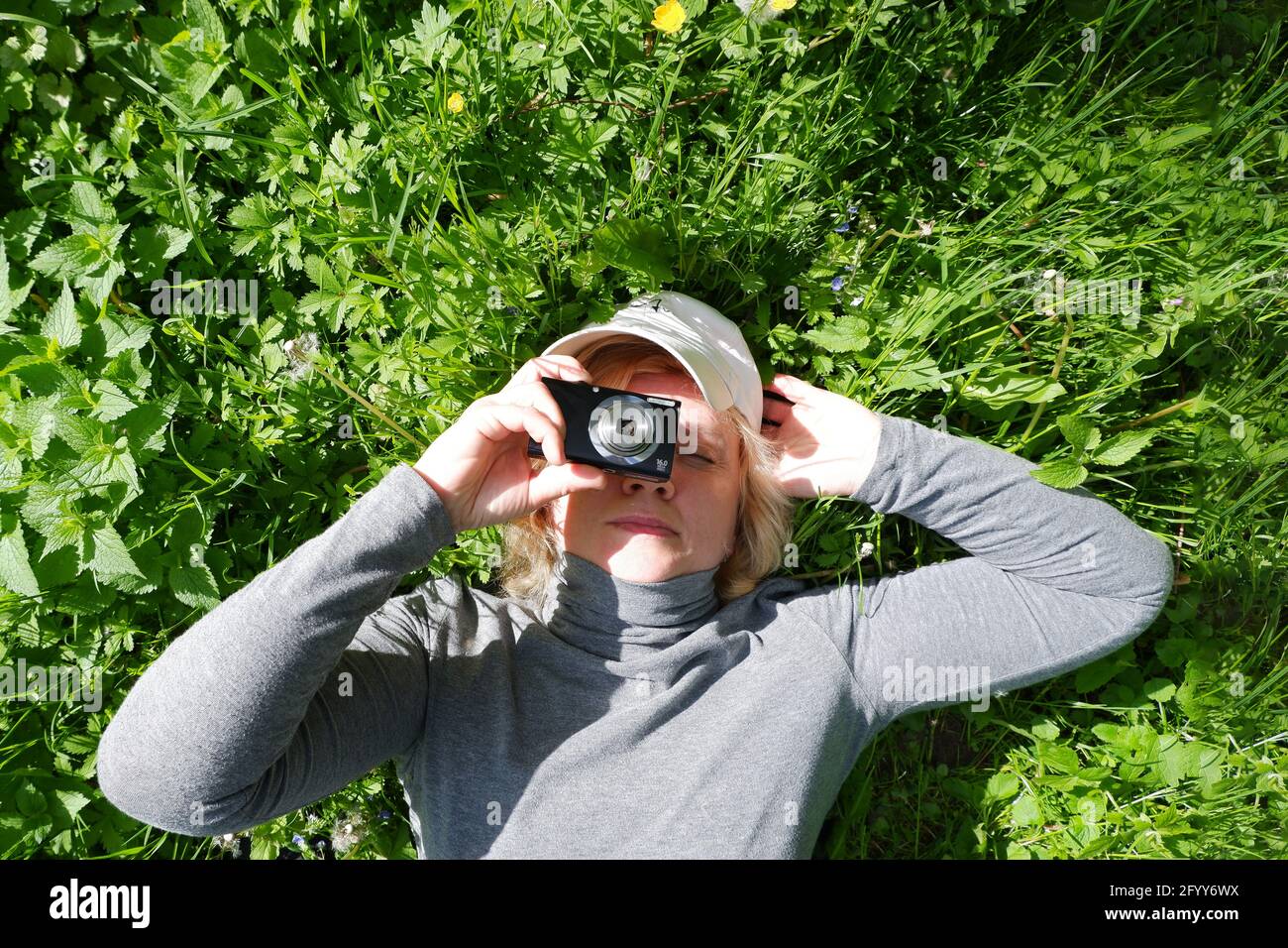 Girl lying on the grass shoots. St. Veronica's Day Photographer's Day . Stock Photo