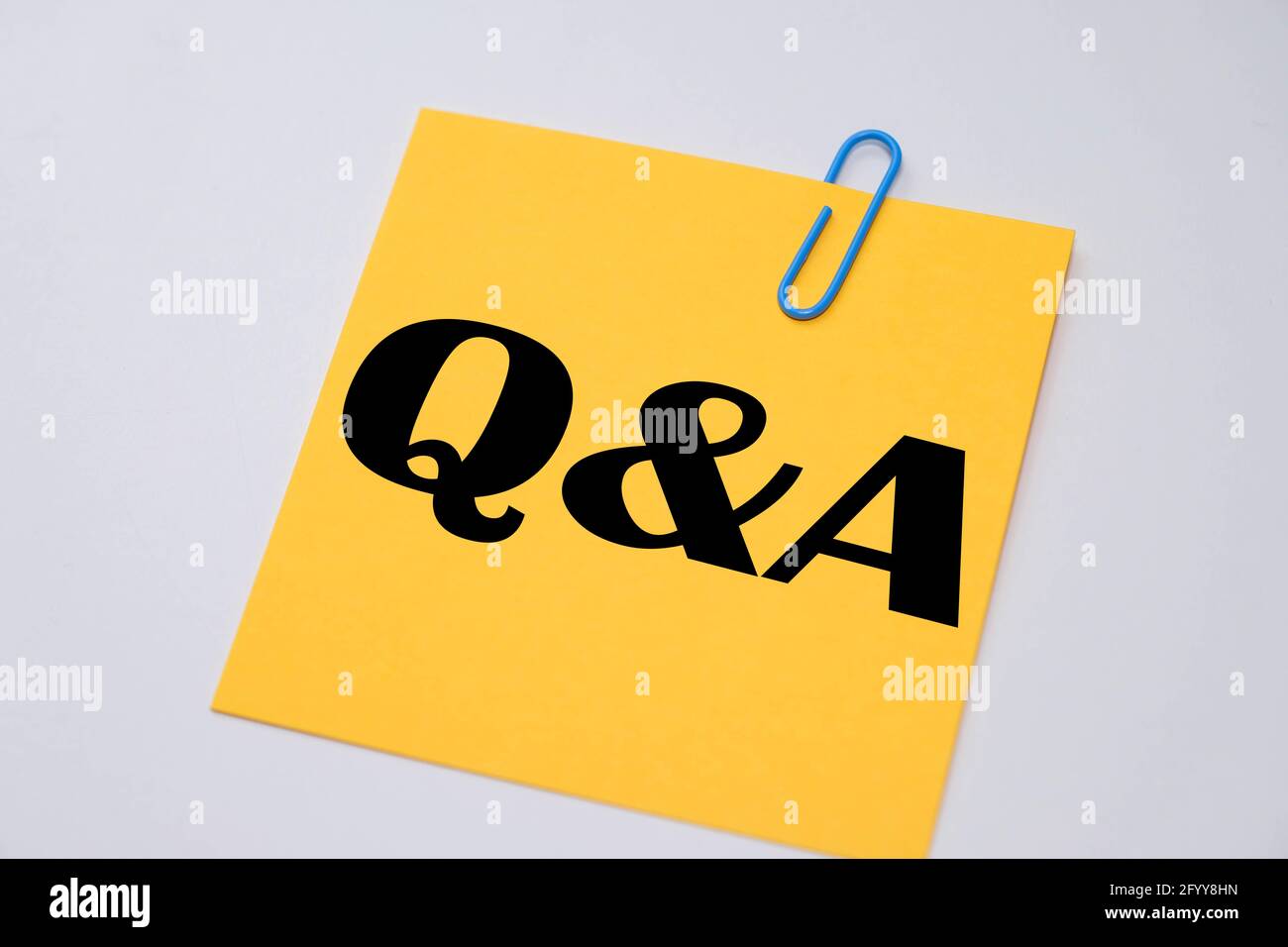 Q&A words on a yellow sticky notes. Stock Photo