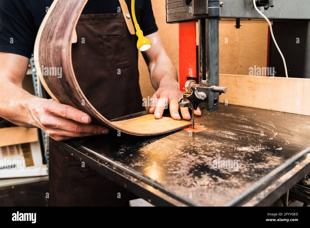 Crop unrecognizable craftsman building wooden musical instrument on