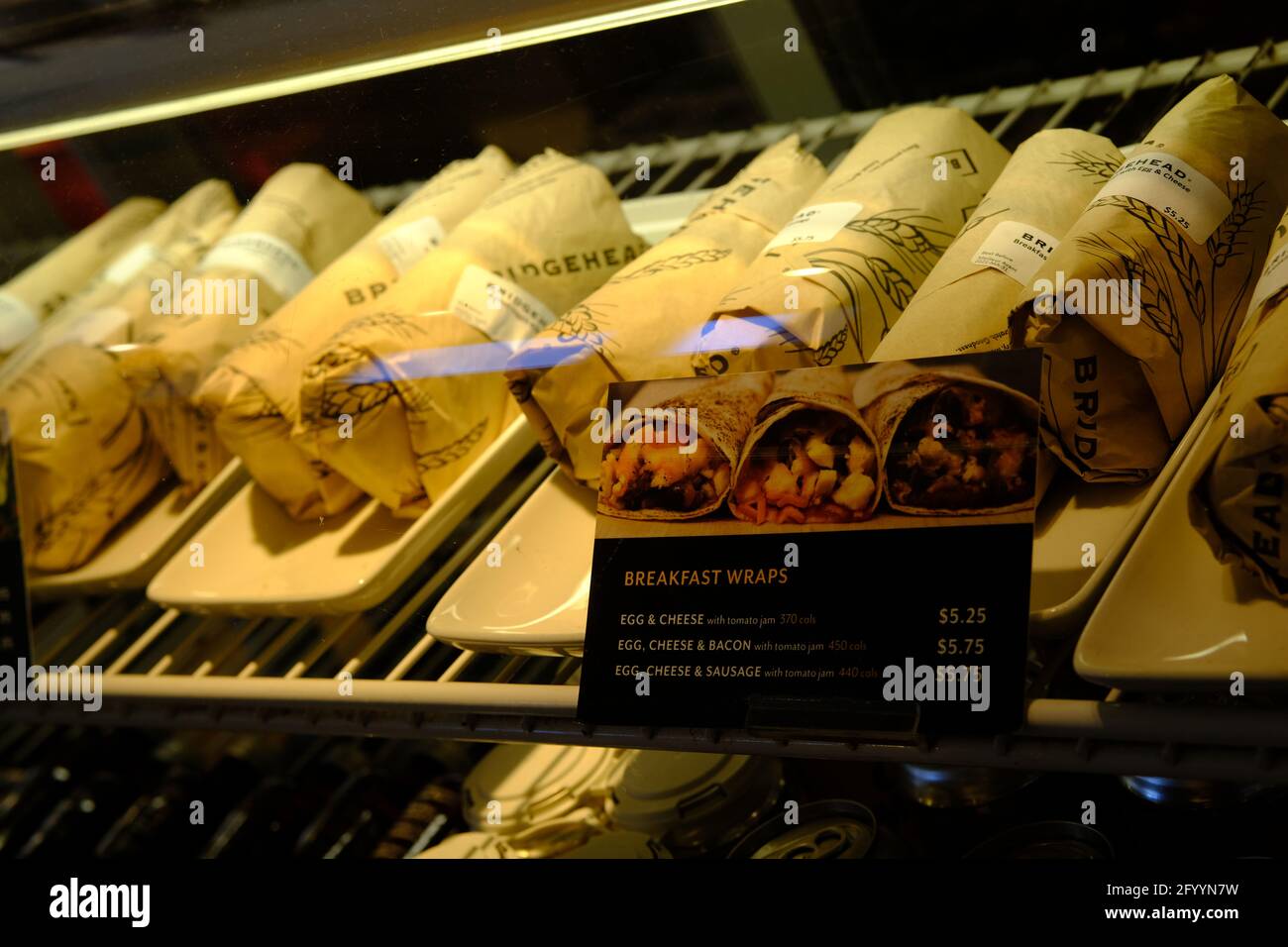 A selection of breakfast wraps behind glass and under yellow lights at a local cafe in Ottawa, Ontario, Canada. Stock Photo