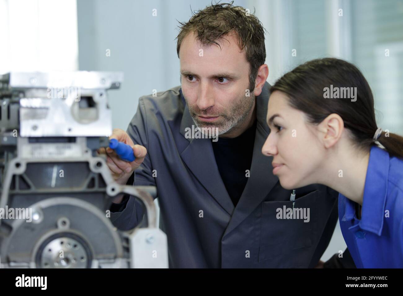 instructor with trainees working on car engine Stock Photo