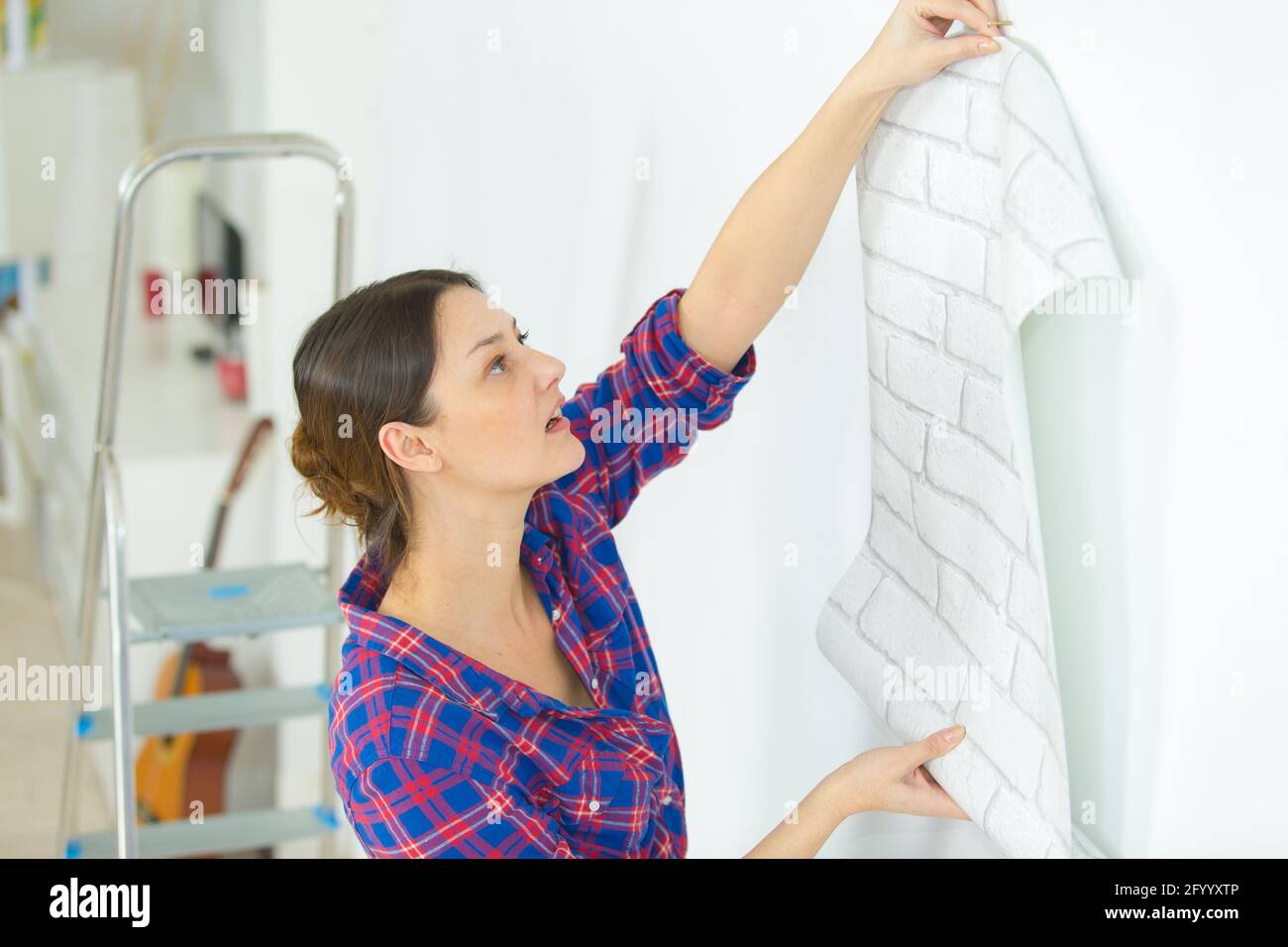 portrait of woman putting up wallpaper Stock Photo Alamy