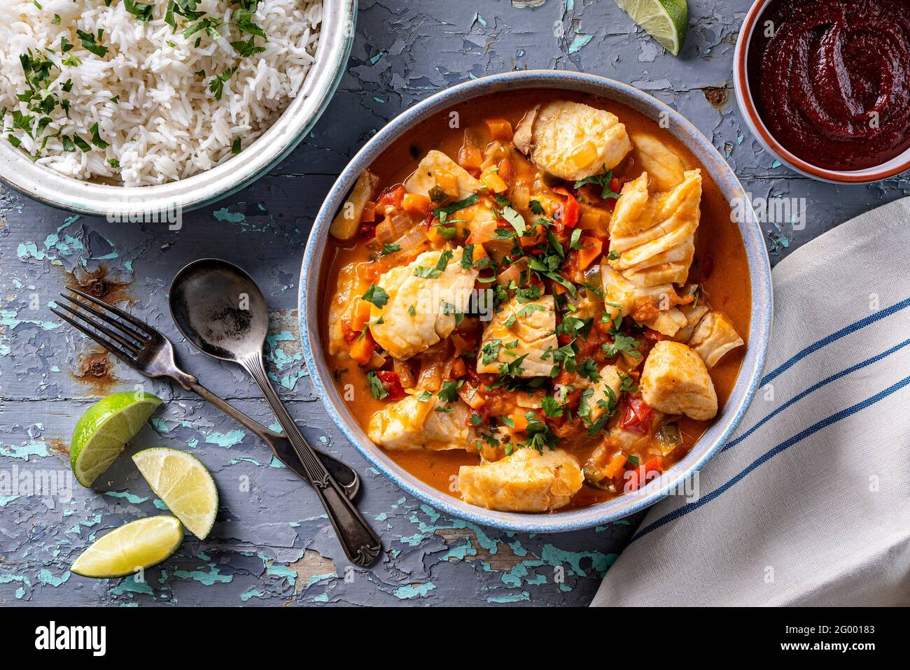 Delicious Brazilian fish stew moqueca with tomato, lime, red pepper, coconut milk and cilantro. Stock Photo