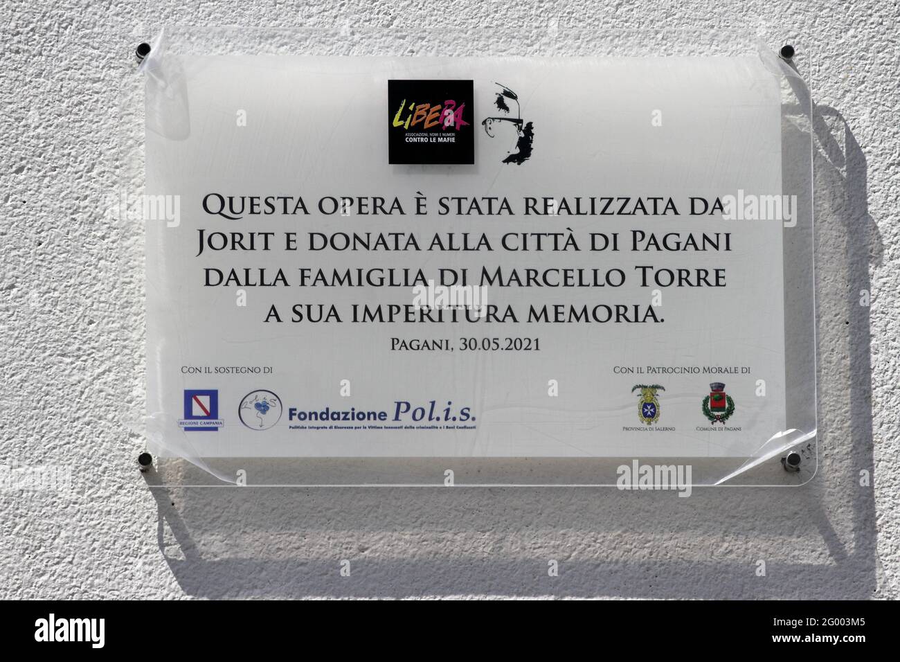 Pagani, Salerno, Italy - May 30, 2021 : It was inaugurated in the presence of the political and civil authorities of the city of Pagani, of the daughter Annamaria Torre, of the members of the Association Marcello Torre and of the Presidio di Pagani of the Free Association (Associations, names and numbers against the mafias), a mural dedicated to the memory of the lawyer Marcello Torre, former mayor of Pagani died on December 11, 1980 at the hands of the Camorra .The work of art depicting the face of the pagan politician and lawyer much loved by all, was entrusted to the skill and hands of Stock Photo
