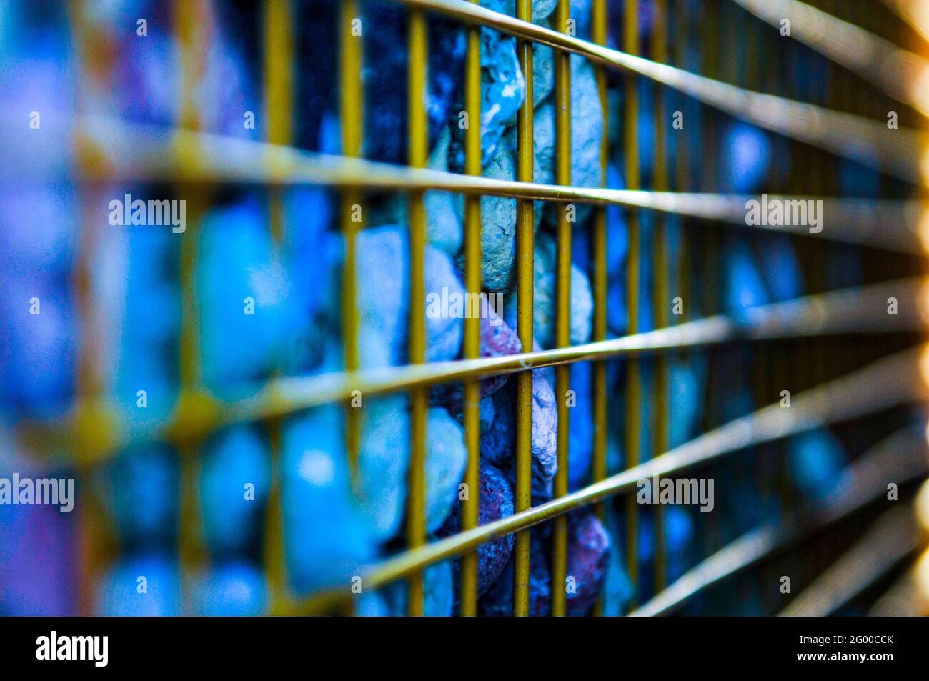 Image Net Rocks Selective focus of colorful painted rocks covered with a metal net ...