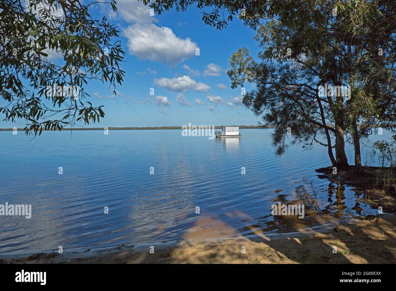 Tranquil landscape with blue sky reflected in mirror surface of calm water of Lake Cootharaba at Boreen Point, Sunshine Coast, Queensland Australia Stock Photo