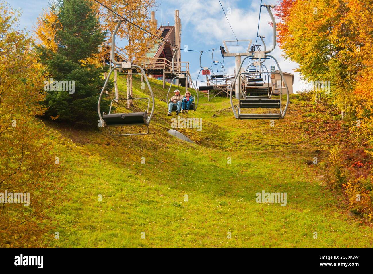 Two people, a man and a woman, ride the ski lift down after visiting