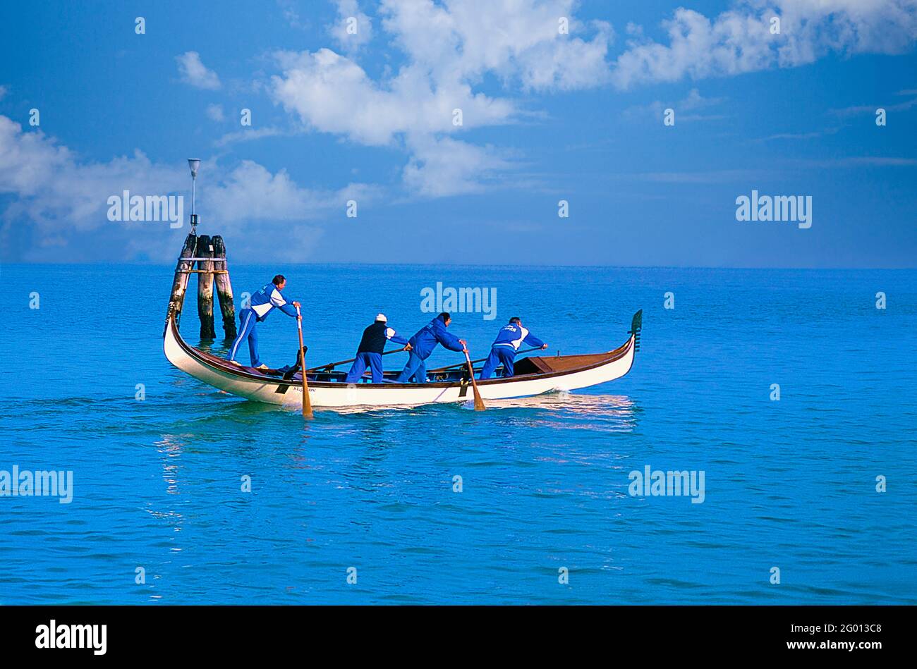 Image of a four man team training for a regatta in the Venice Lagoon. Stock Photo