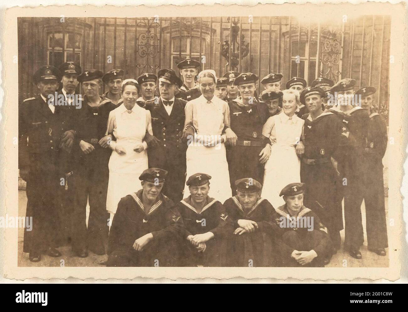 Sailors and three nurses in Paris. Group of sailors in uniform and three nurses posing for a fence in Paris, early May 1943. Four of the Marines are in front of their squat. Part of the Loose Photos group associated with the photo album over the Kriegsmarine 1940-1943. Stock Photo