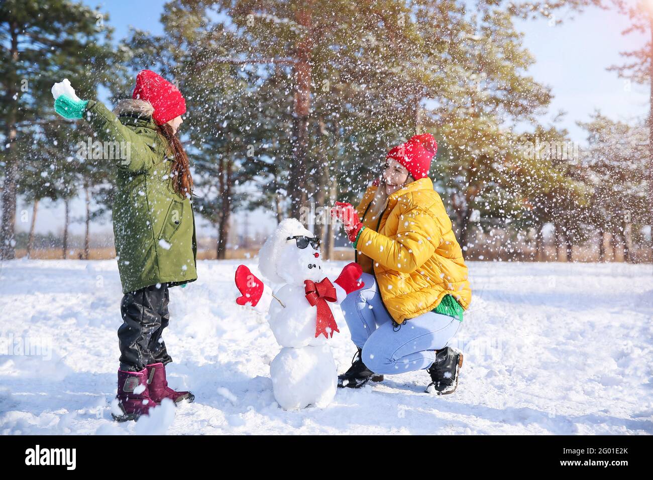 Happy family playing snowballs in park Stock Photo - Alamy