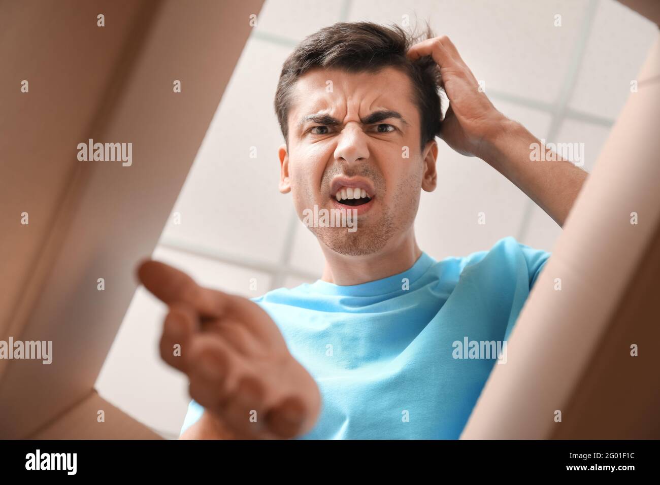 Angry young man with open box, view from inside Stock Photo Alamy