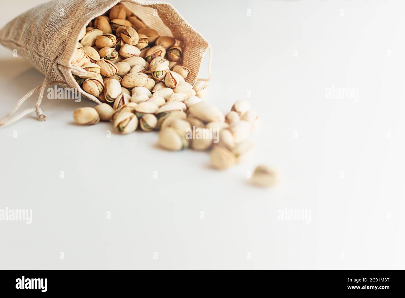 Pile of pistachios on the light background. Pistachio is a healthy