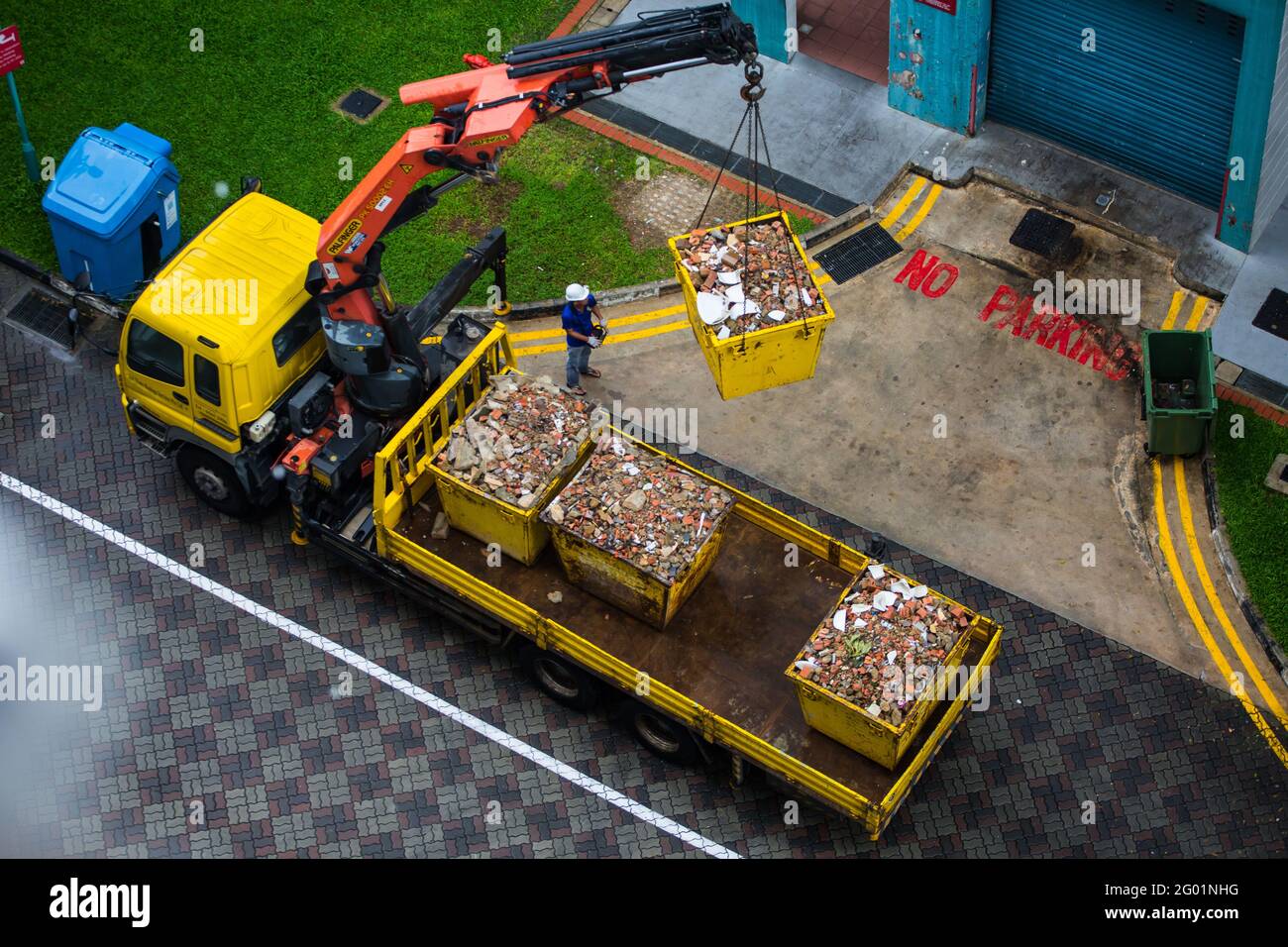 Aerial view of an operator using technology to lift up the heavy container onto the back of the truck. Stock Photo