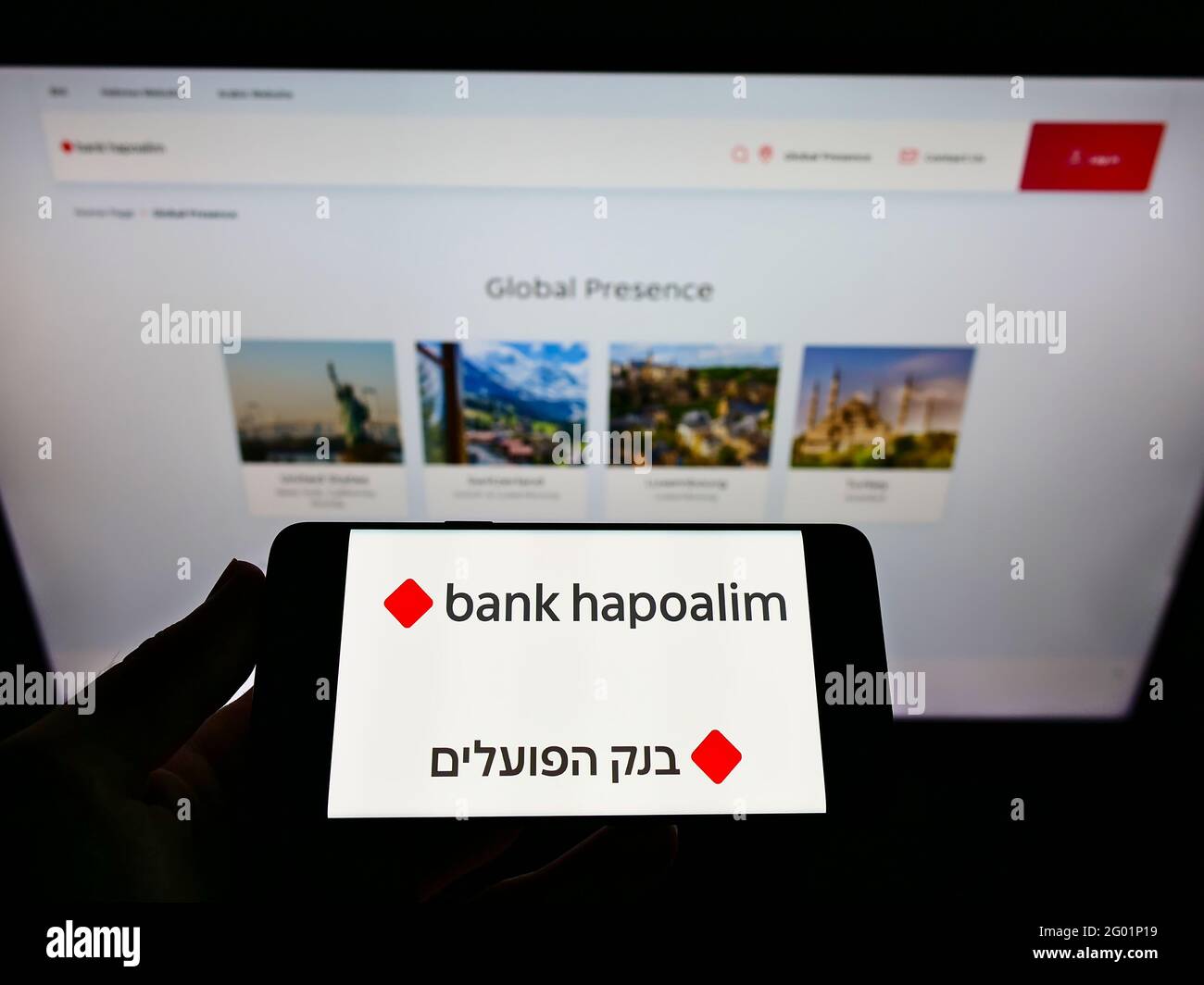 Person holding smartphone with logo of Israeli financial company Bank Hapoalim B.M. on screen in front of website. Focus on phone display. Stock Photo