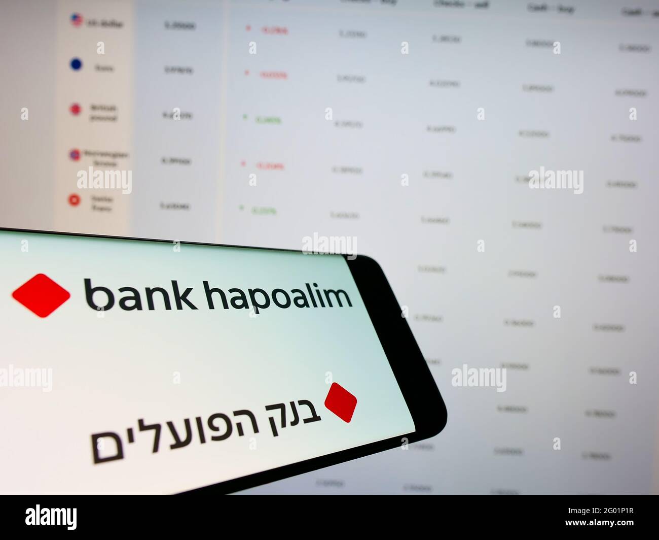 Cellphone with logo of Israeli financial company Bank Hapoalim B.M. on screen in front of business web page. Focus on center-right of phone display. Stock Photo