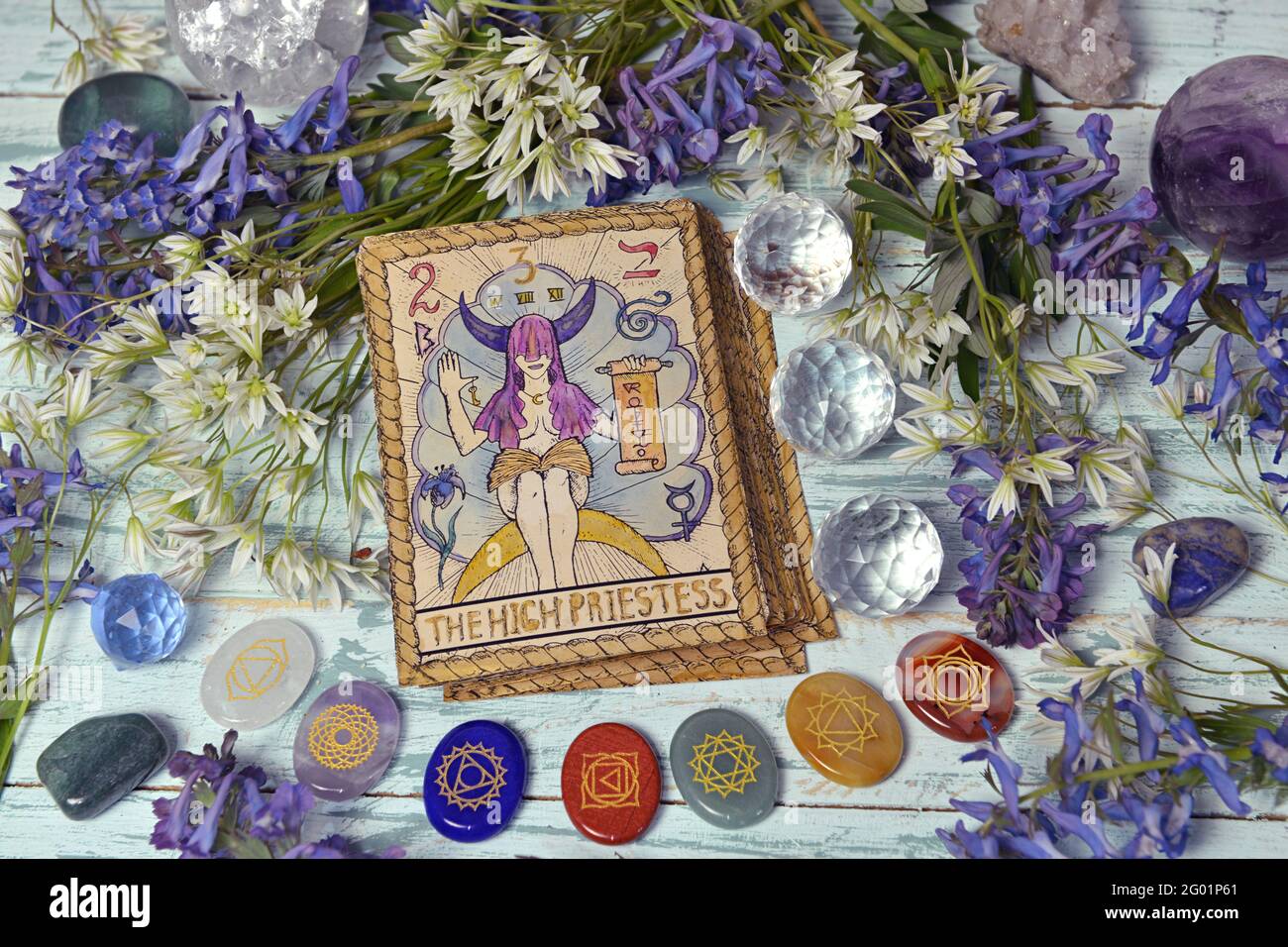 Still life with High Priestess card of the old tarot deck on witch altar table with chakra crystals and flowers. Esoteric, gothic and occult backgroun Stock Photo