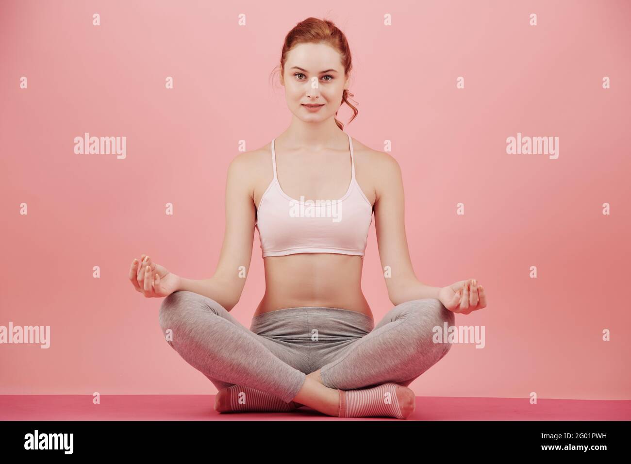 Smiling Position Studio portrait of beautiful smiling slim young woman sitting in lotus ...