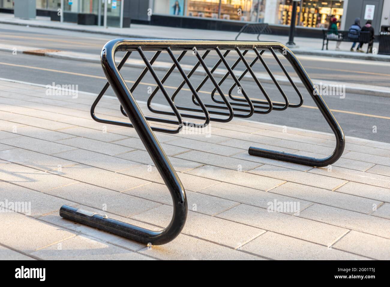 Bike rack for parking bicycles in the street of downtown of Ottawa, Canada. Bycycle stand on pavement near road in the city. Stock Photo