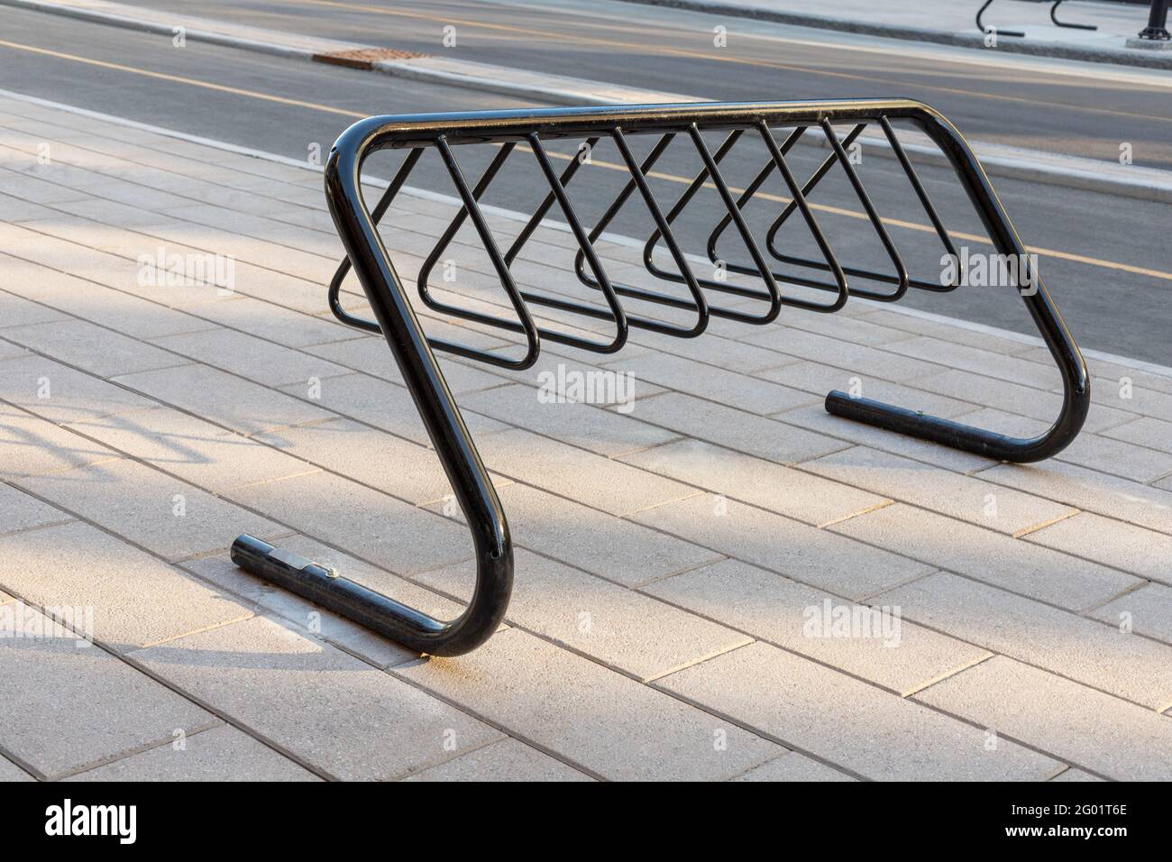 Bike rack for parking bicycles in the street of downtown of Ottawa, Canada. Bycycle stand on pavement near road in the city. Stock Photo