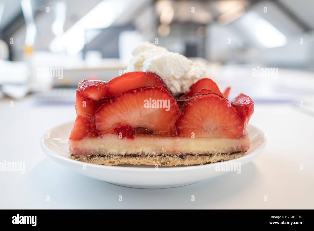 Traditional German sliced fresh strawberry cake tart or pie on topped with whipped cream Stock