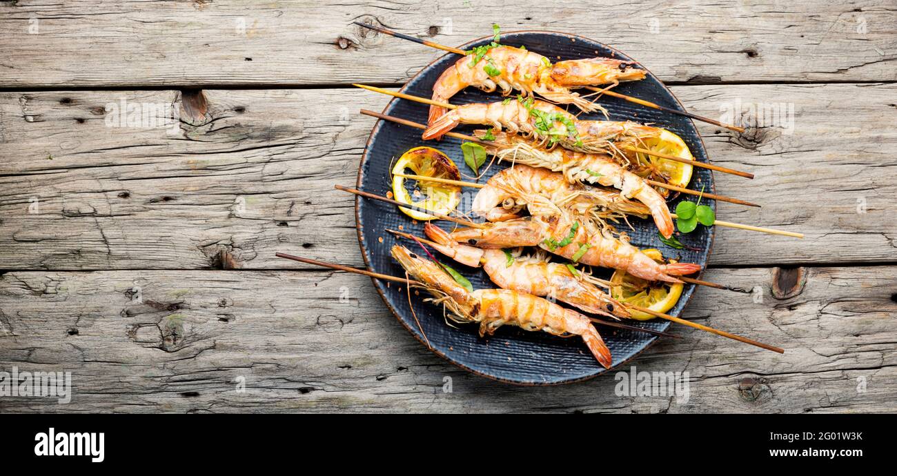 Grilled langoustines,prawn roasted on a skewer.Grilled seafood plate.Copy space Stock Photo