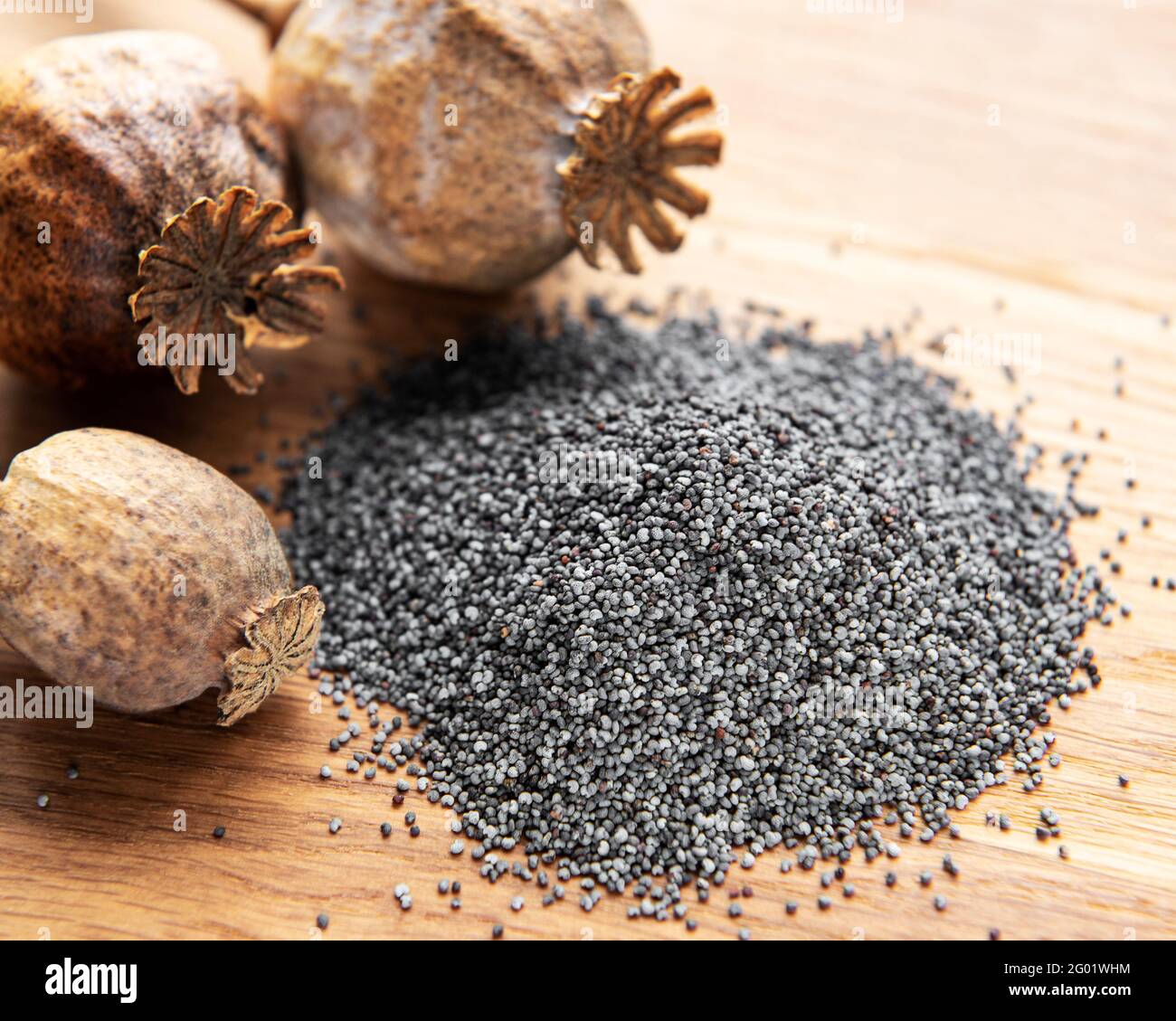 Poppy seeds and poppyhead on the wooden table Stock Photo