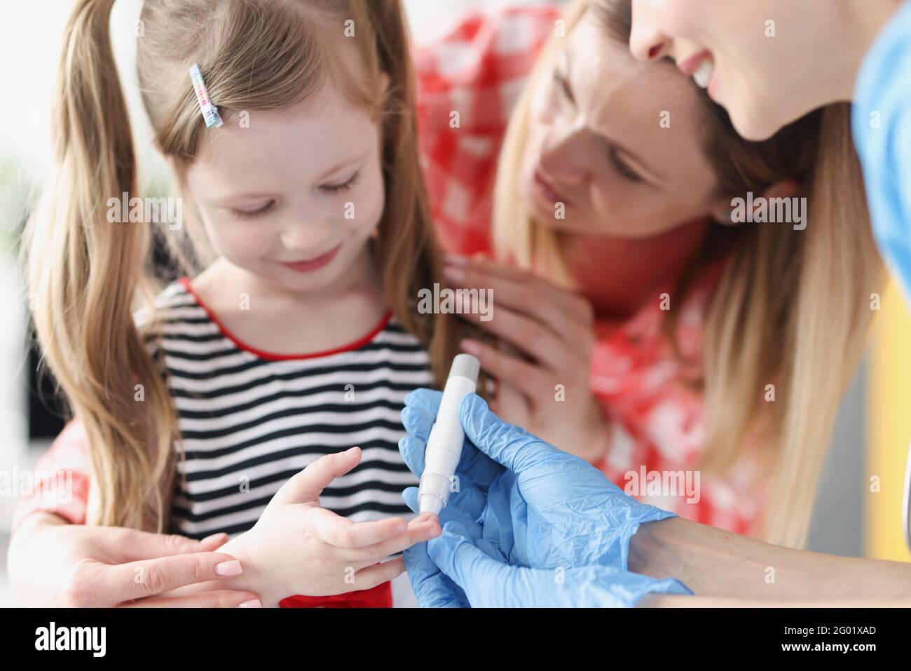 Doctor takes blood test with lancet from little girl Stock Photo Alamy
