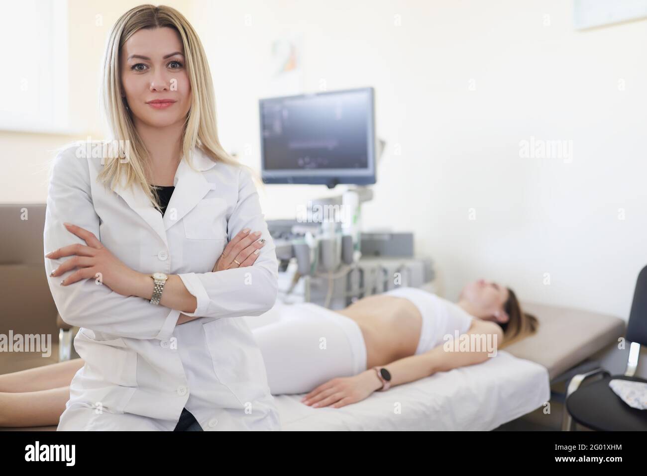 Portrait of doctor in office for ultrasound examination of internal organs in background is patient Stock Photo