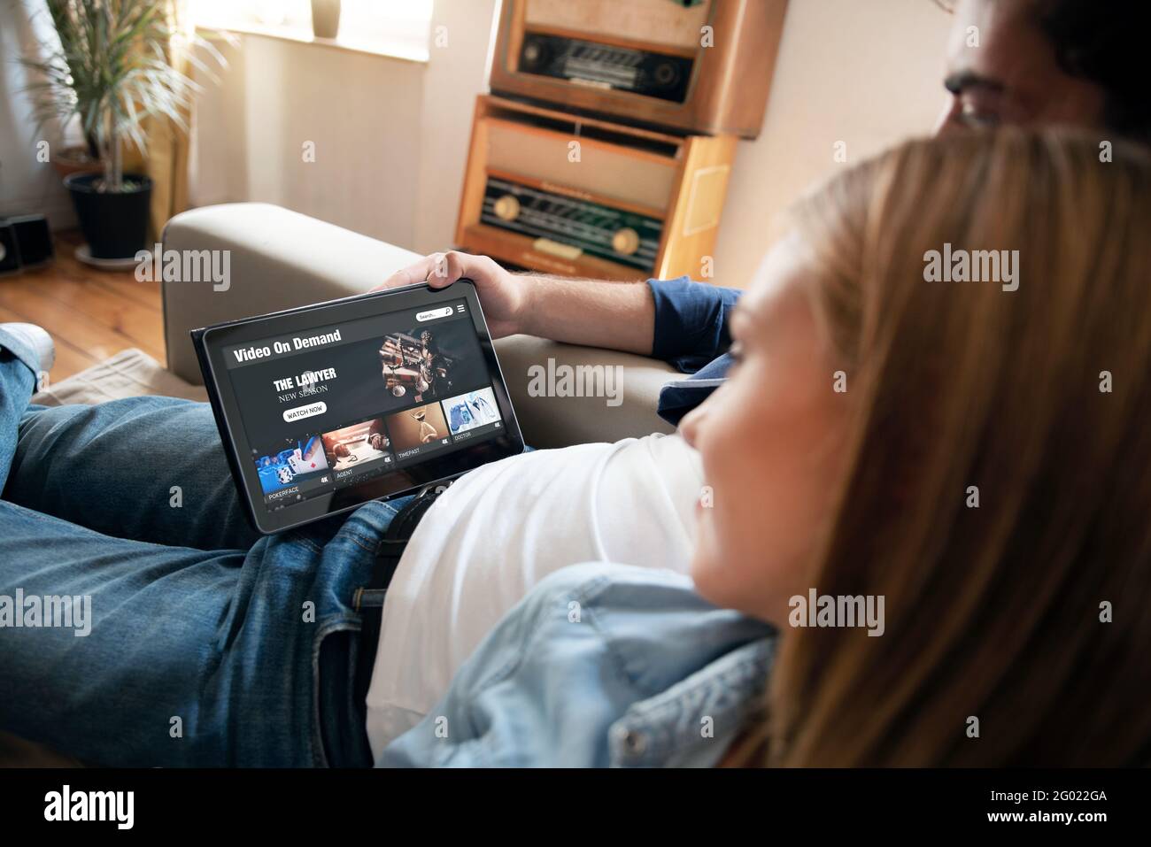 Video on demand, TV streaming, multimedia. Couple with tablet Stock Photo