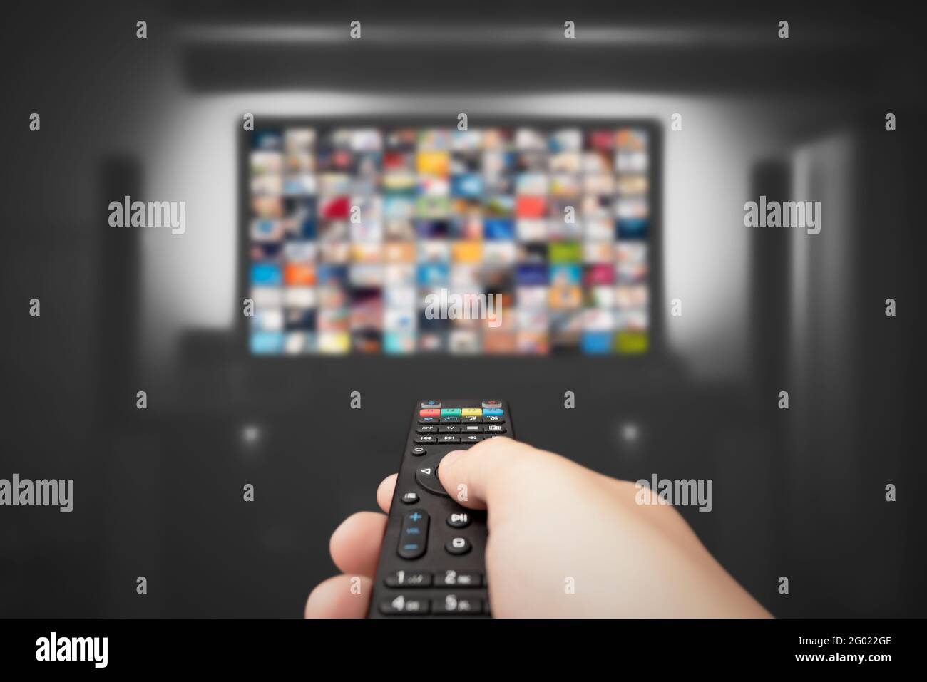 Video on demand, TV streaming, multimedia. Hand holding remote control Stock Photo