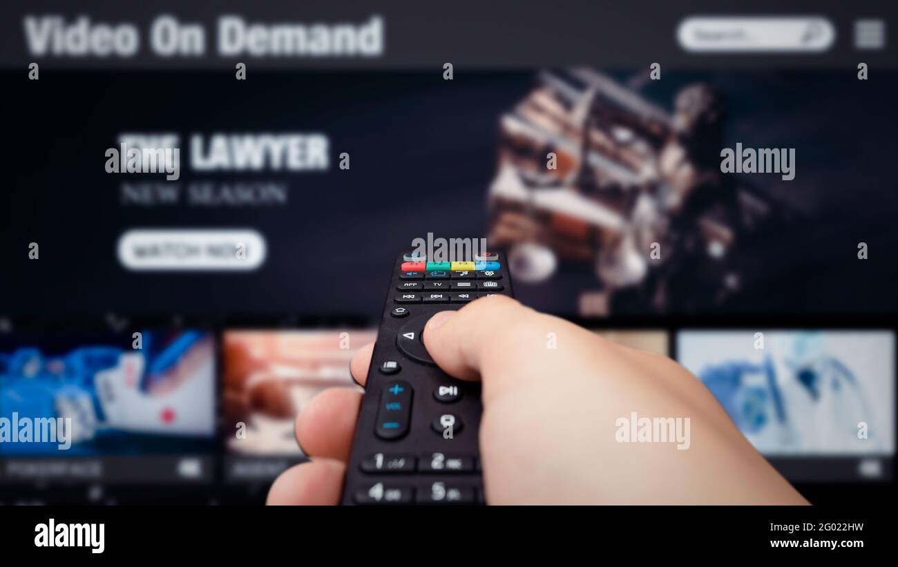 Video on demand, TV streaming, multimedia. Hand holding remote control Stock Photo