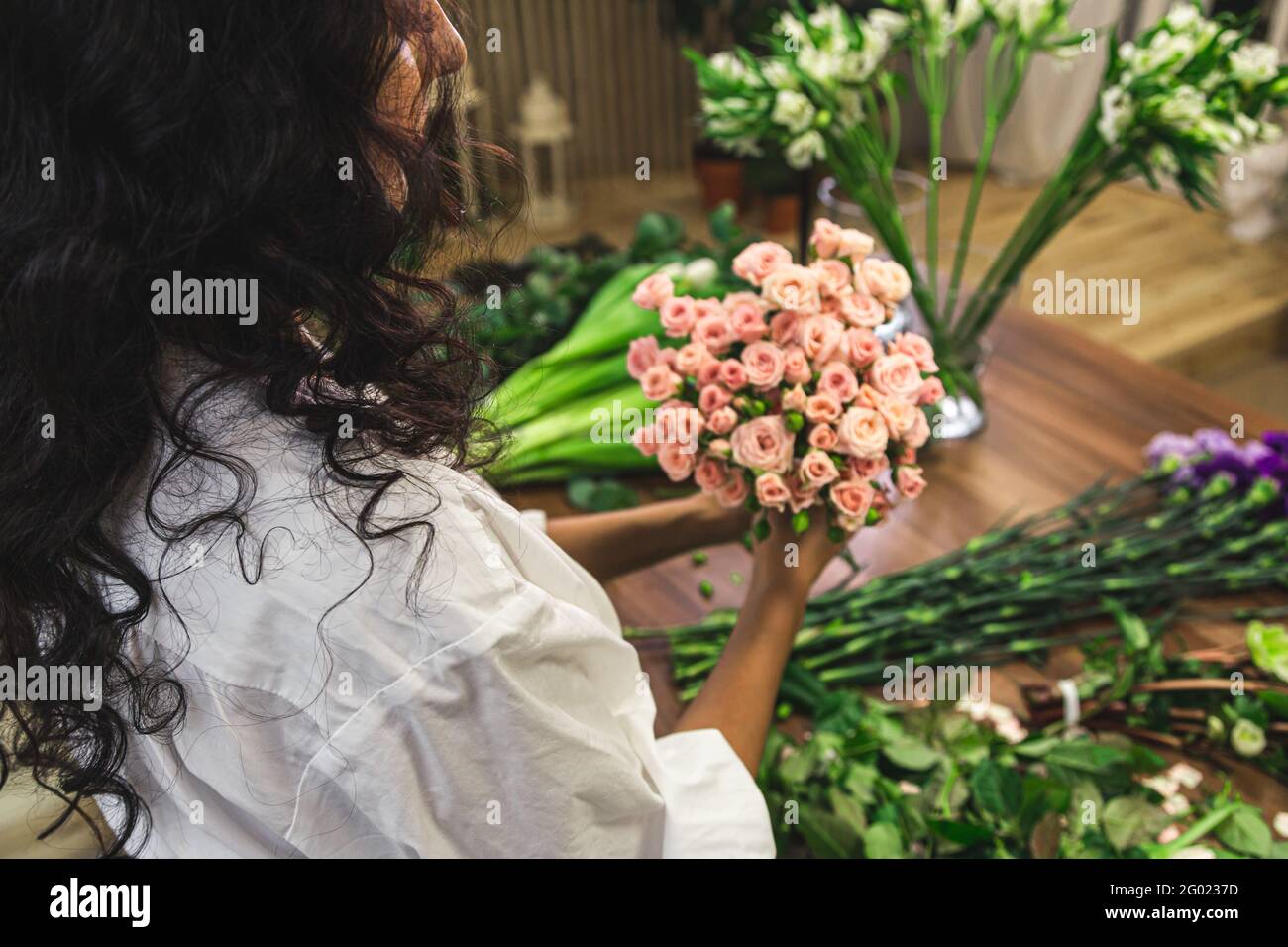 Attractive young woman florist is working in a flower shop Stock Photo ...