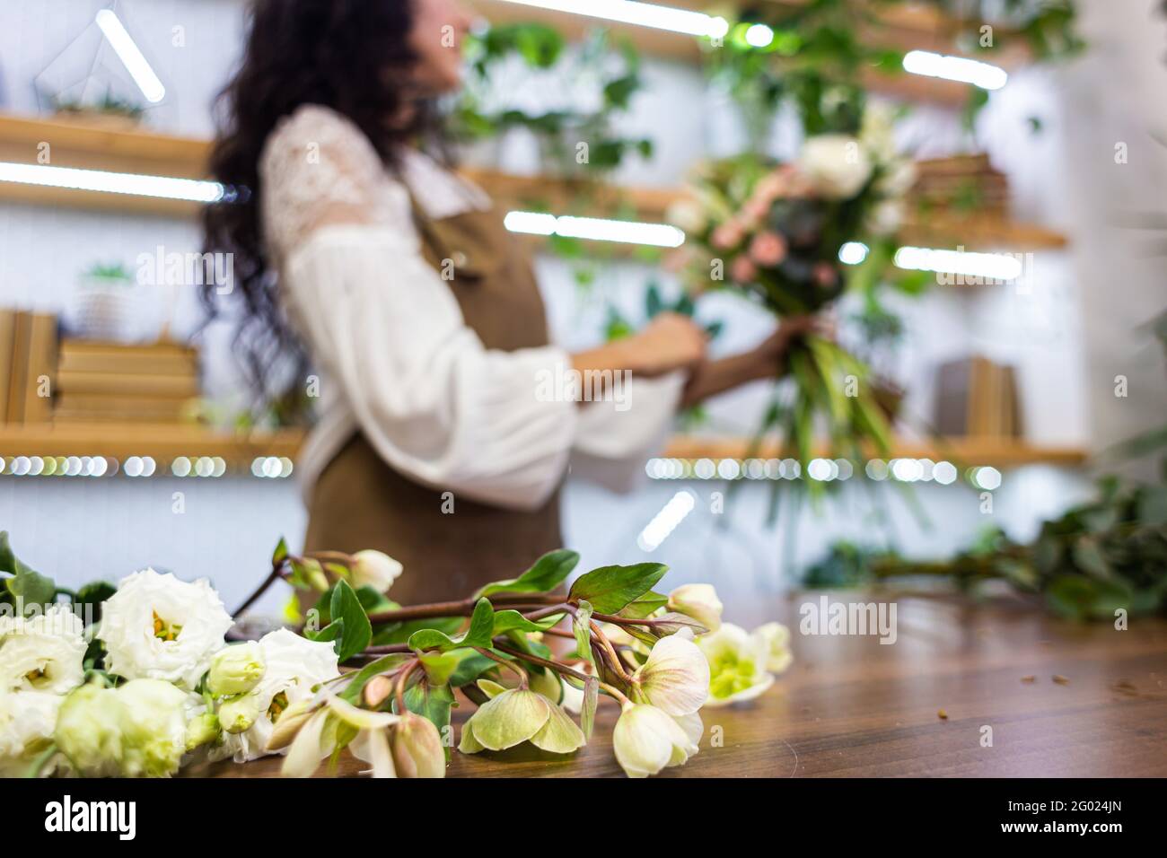 Attractive young woman florist is working in a flower shop Stock Photo ...