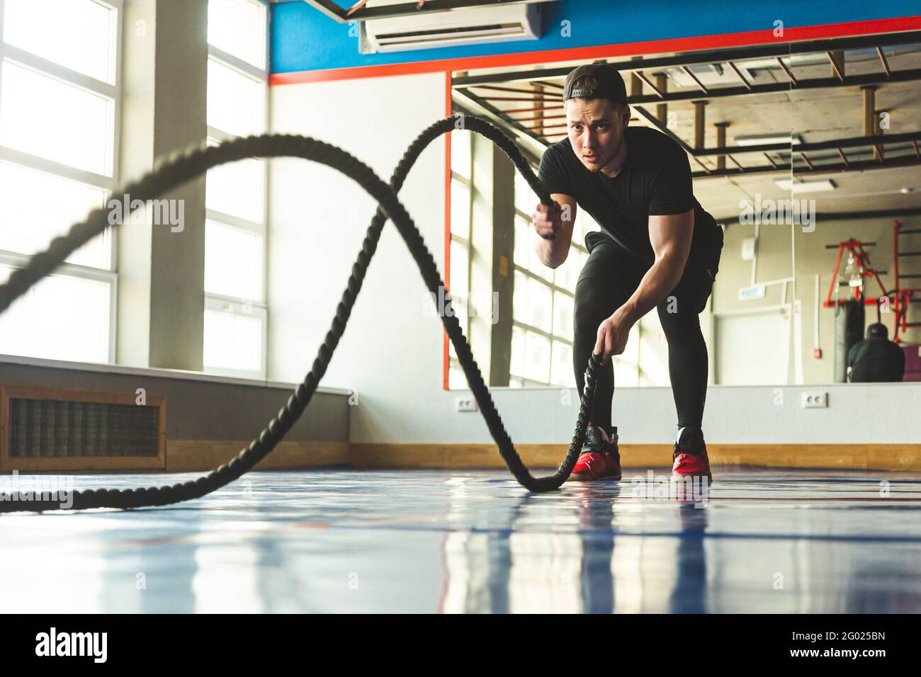 Crossfit in the gym with ropes. The athlete is training Stock Photo - Alamy