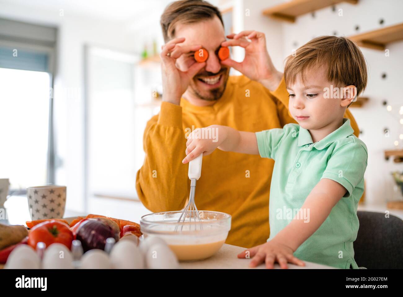 Smiling father with kids preparing healthy food and spending time together Stock Photo