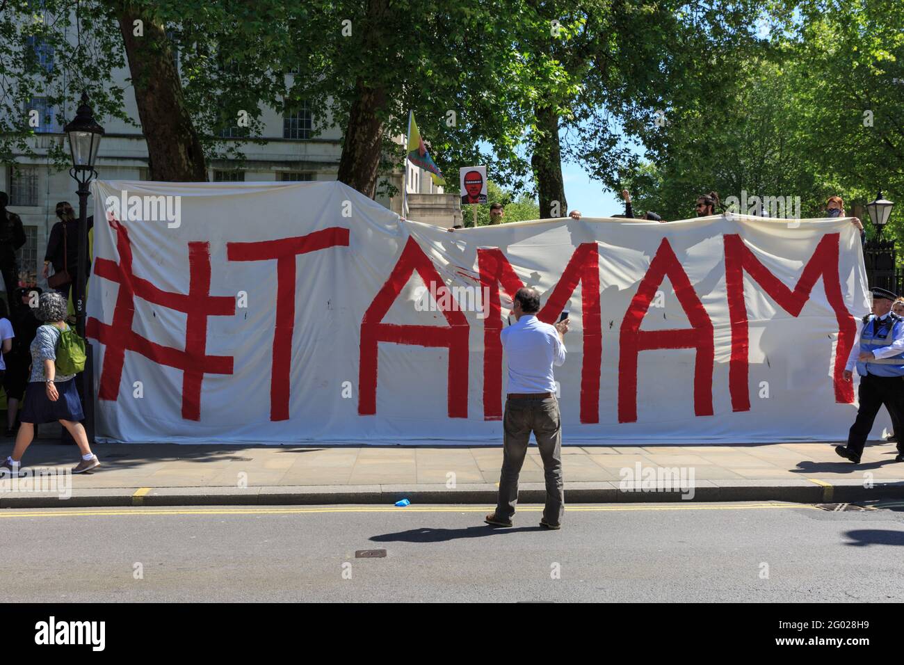 Kurdish Protesters hold a banner saying 'Tamam' commenting on the arrival of Turkish president Erdogan in Westminster, London, UK Stock Photo