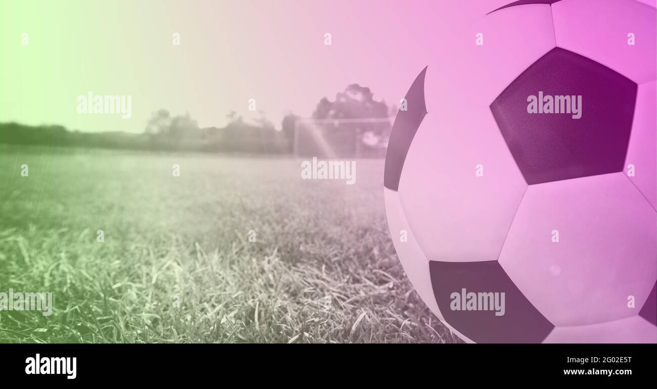 Composition of football on white line on grass pitch with copy space and pink tint Stock Photo