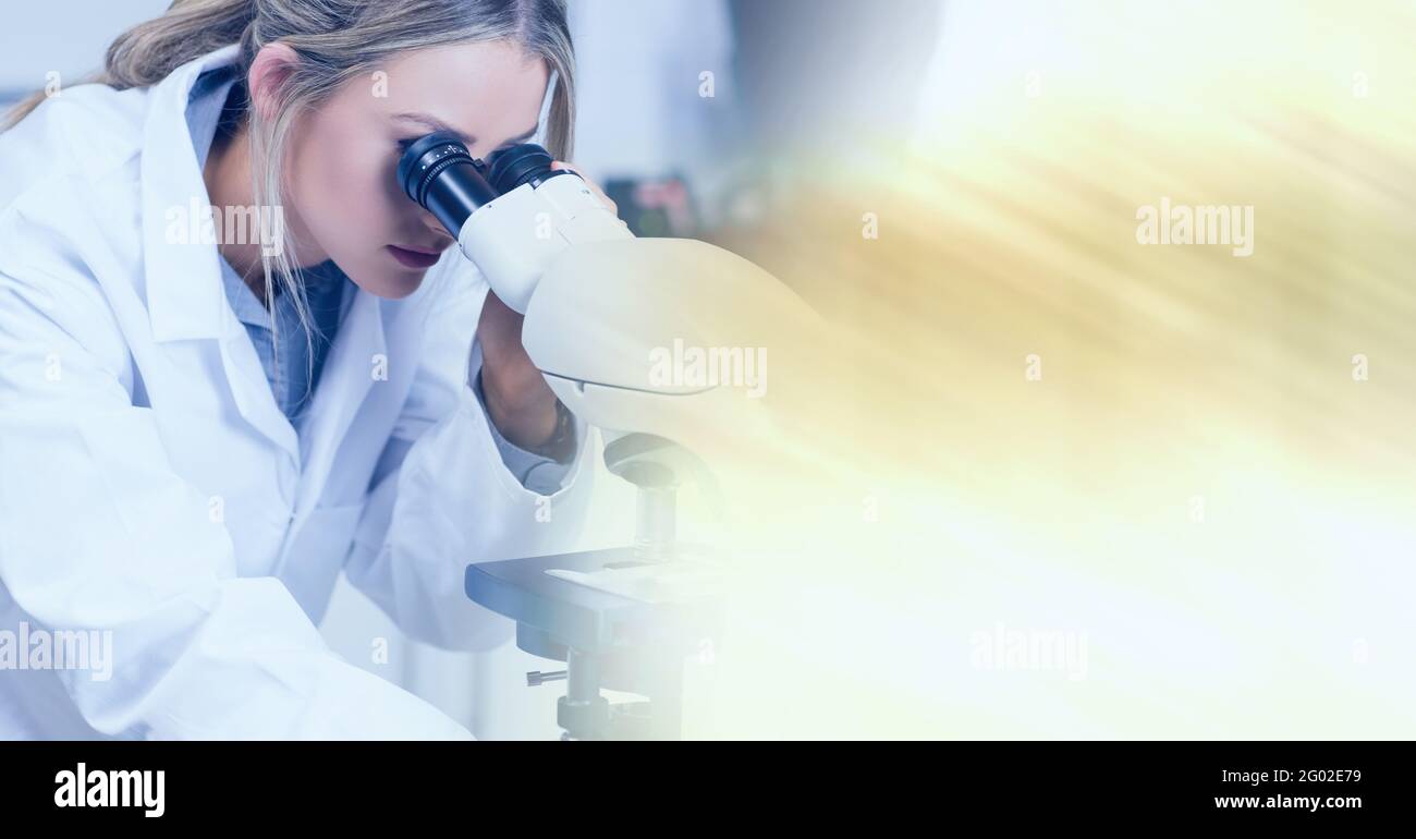 Composition of female lab technician using microscope, with blurred ...