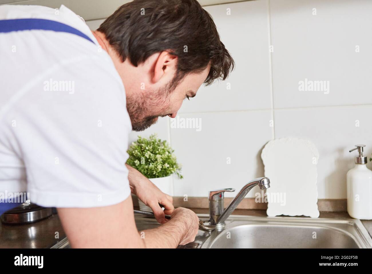 Professional plumber or doityourselfer connecting the kitchen faucet