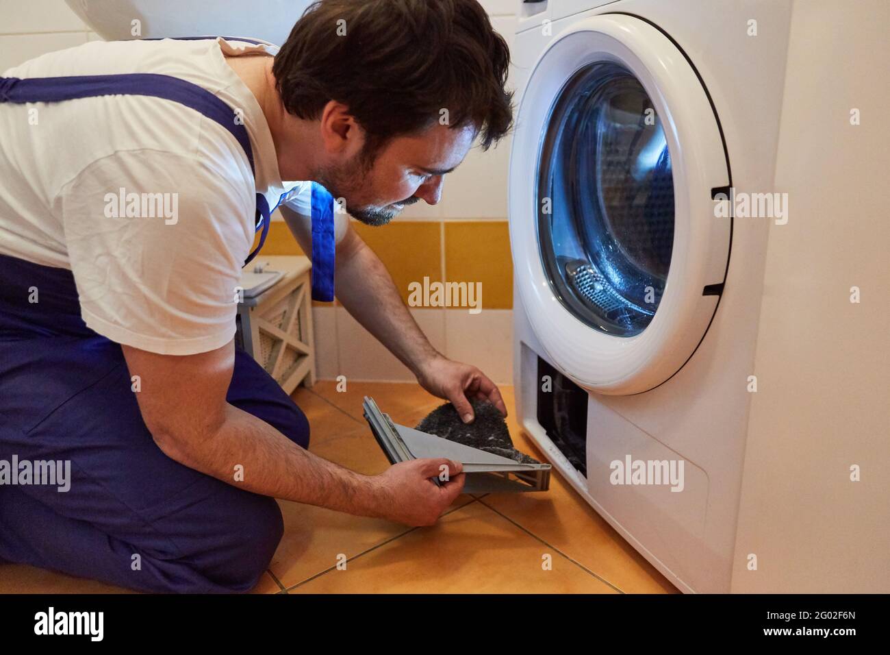 Do-it-yourselfers clean the lint filter from the tumble dryer or washing  machine Stock Photo - Alamy