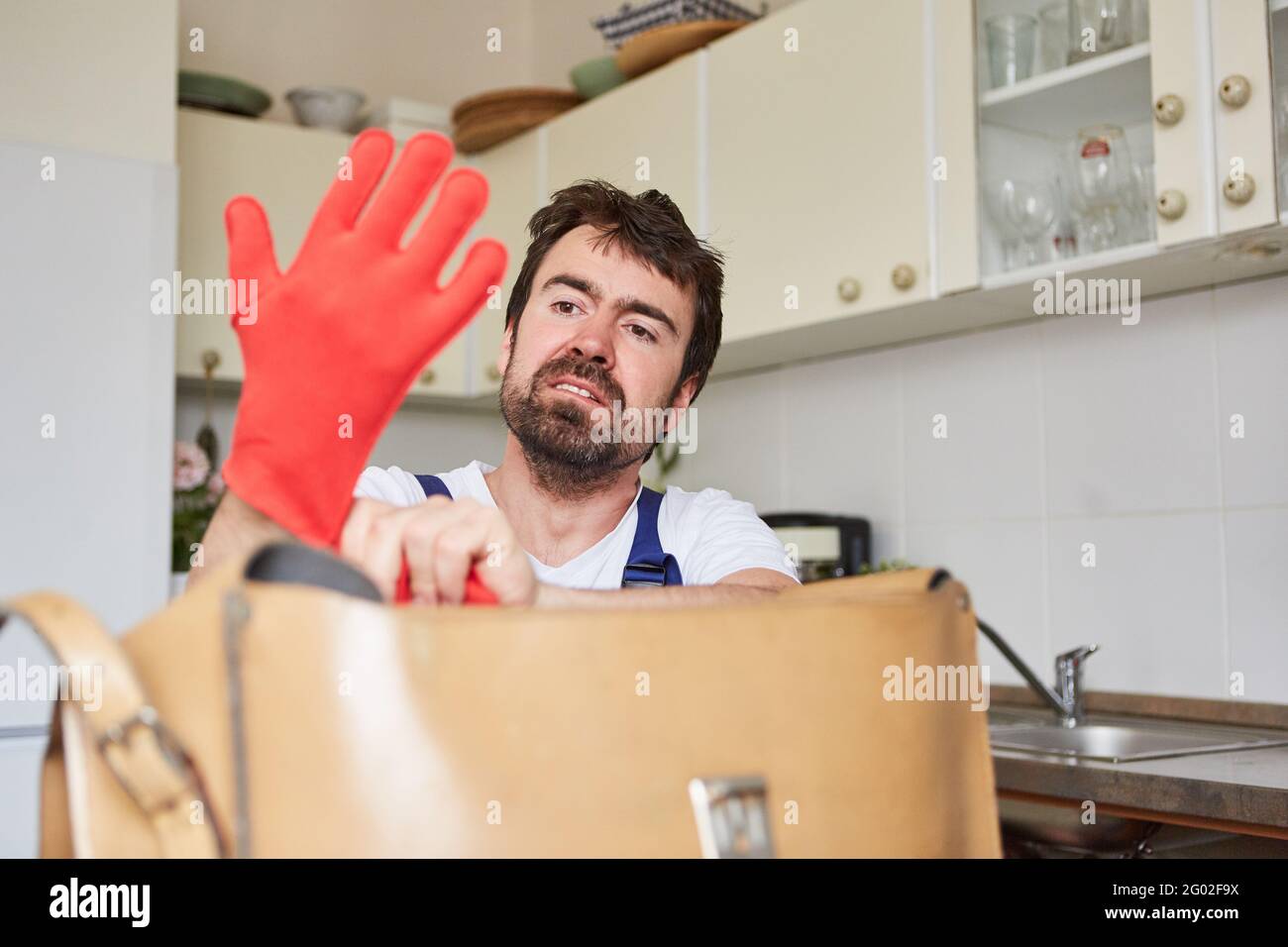 Do-it-yourselfer puts on rubber gloves to repair the drainpipe Stock Photo