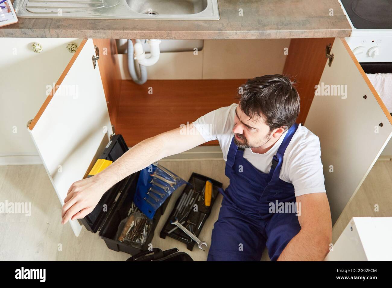 Plumber or plumber installing or assembling a sink in the kitchen Stock Photo