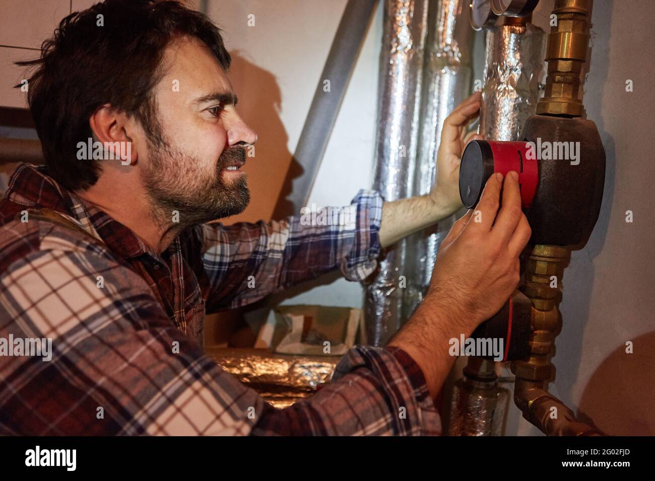 Do-it-yourselfer or heating installer checks the circulation pump on the heating system Stock Photo