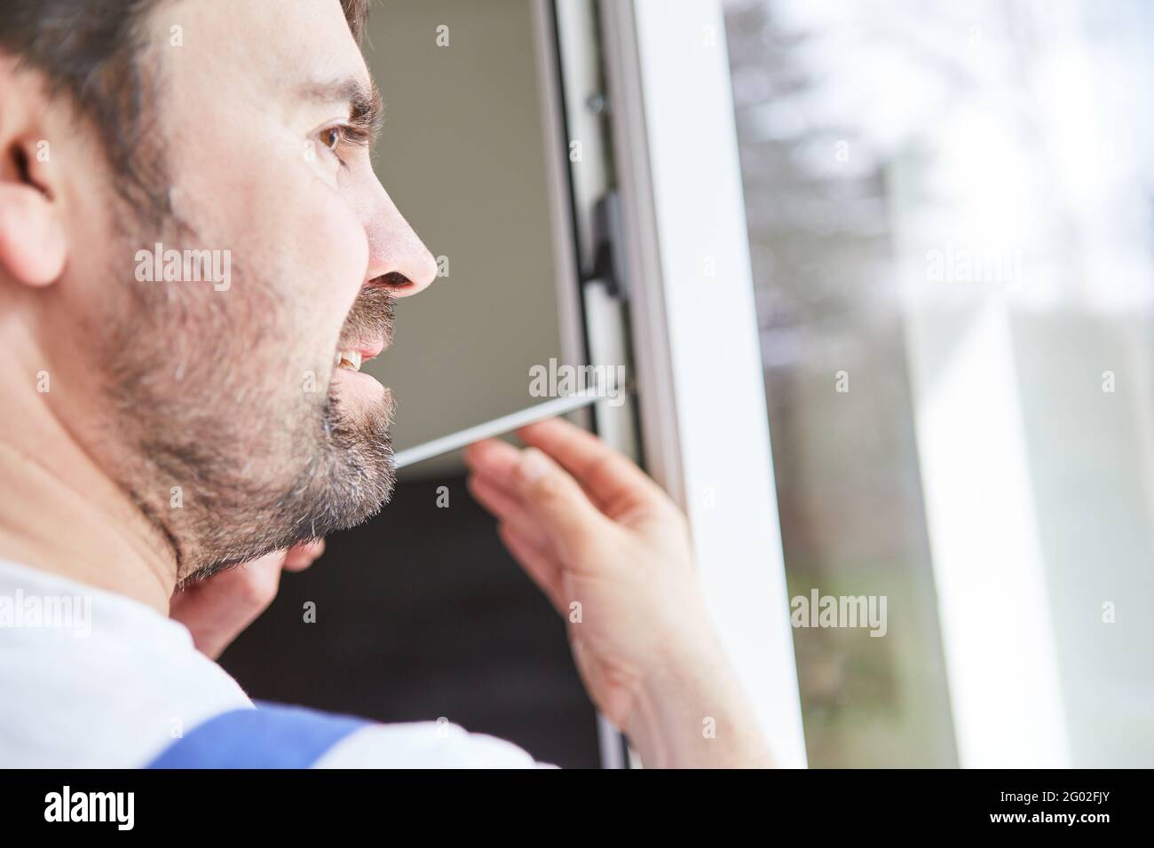 Craftsmen from a specialist company or do-it-yourselfer assemble and adjust the window Stock Photo