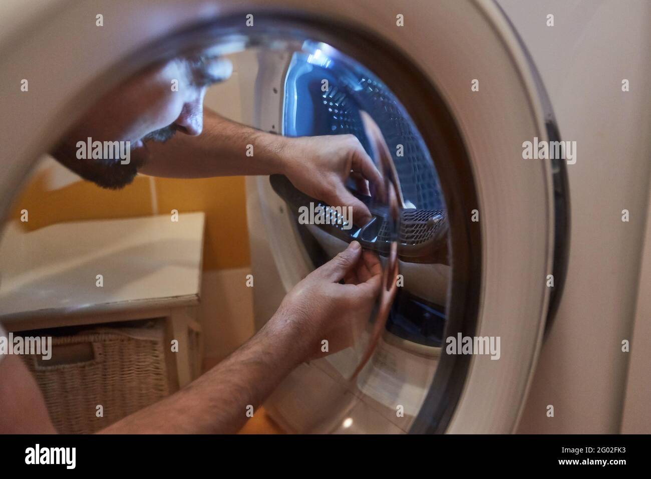 A housewife woman cleans the lint filter of the washing machine or tumble  dryer Stock Photo - Alamy