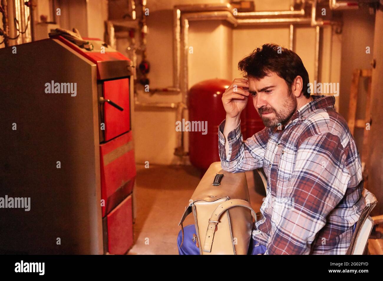 Thoughtful man as a do-it-yourselfer has a problem with the defective heating system Stock Photo
